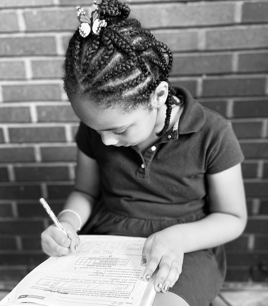 A young Dundas Legacy Academy scholar focused on her workbook